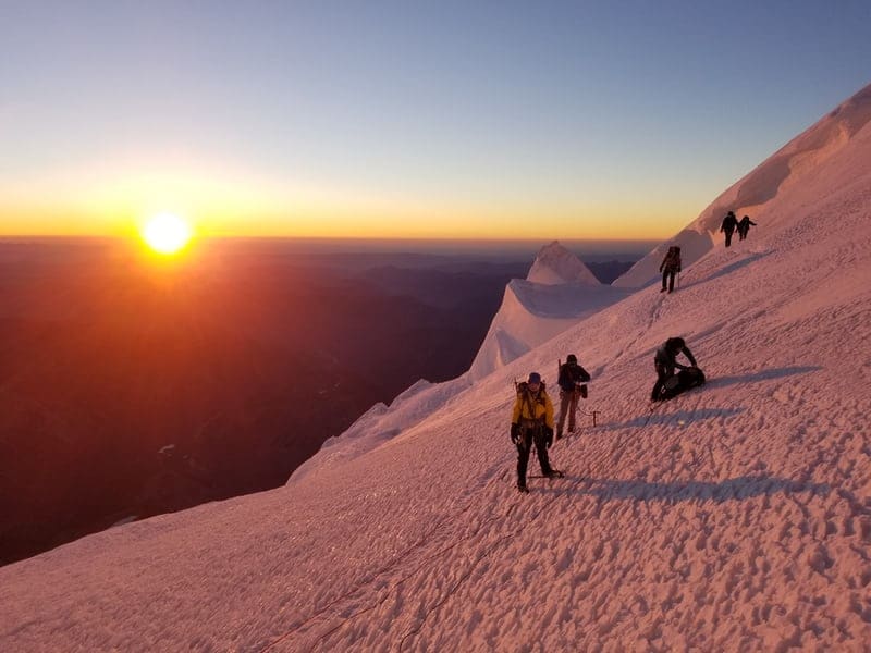 Stage d'alpinisme dans les alpes avec un couché de soleil en haut d'une montagne