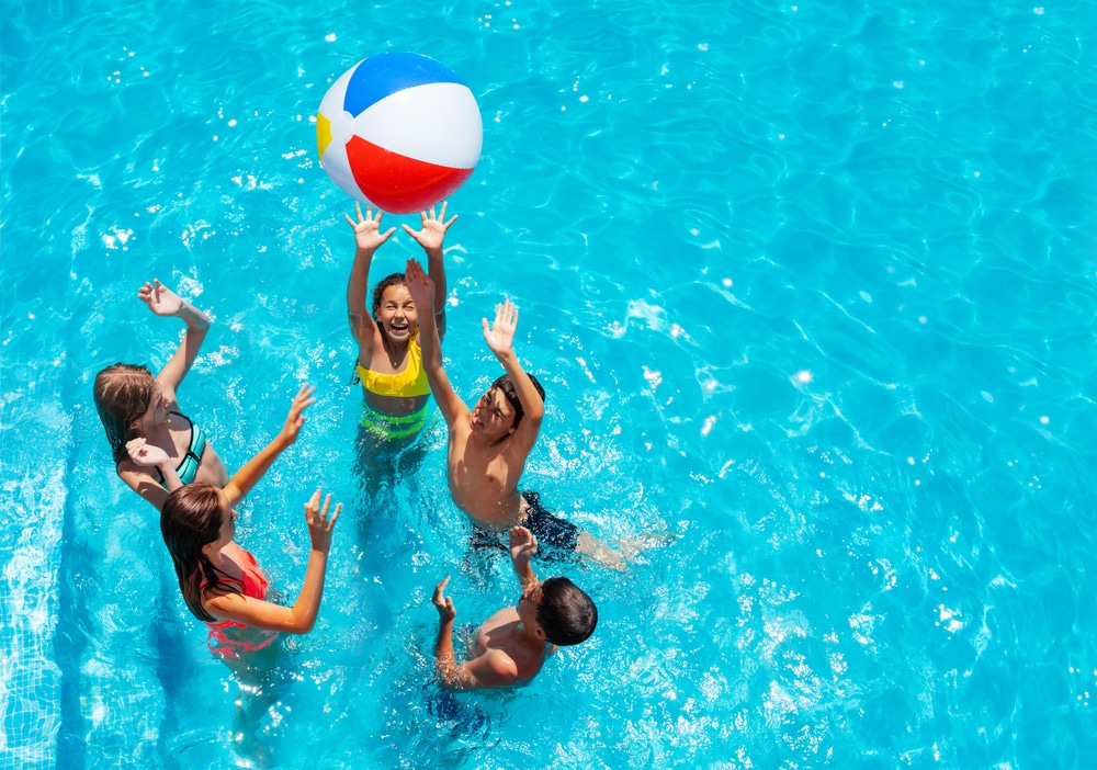 Enfants qui s'amusent dans une piscine avec un ballon dans un camping