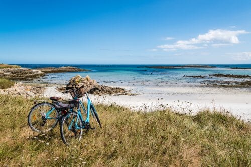 Vélo posé sur une dune face à l'océan en Bretagne
