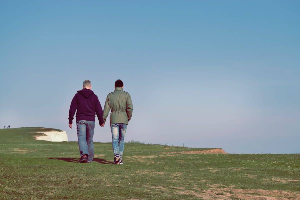 Couple gay marchant sur une falaise pendant leur voyage