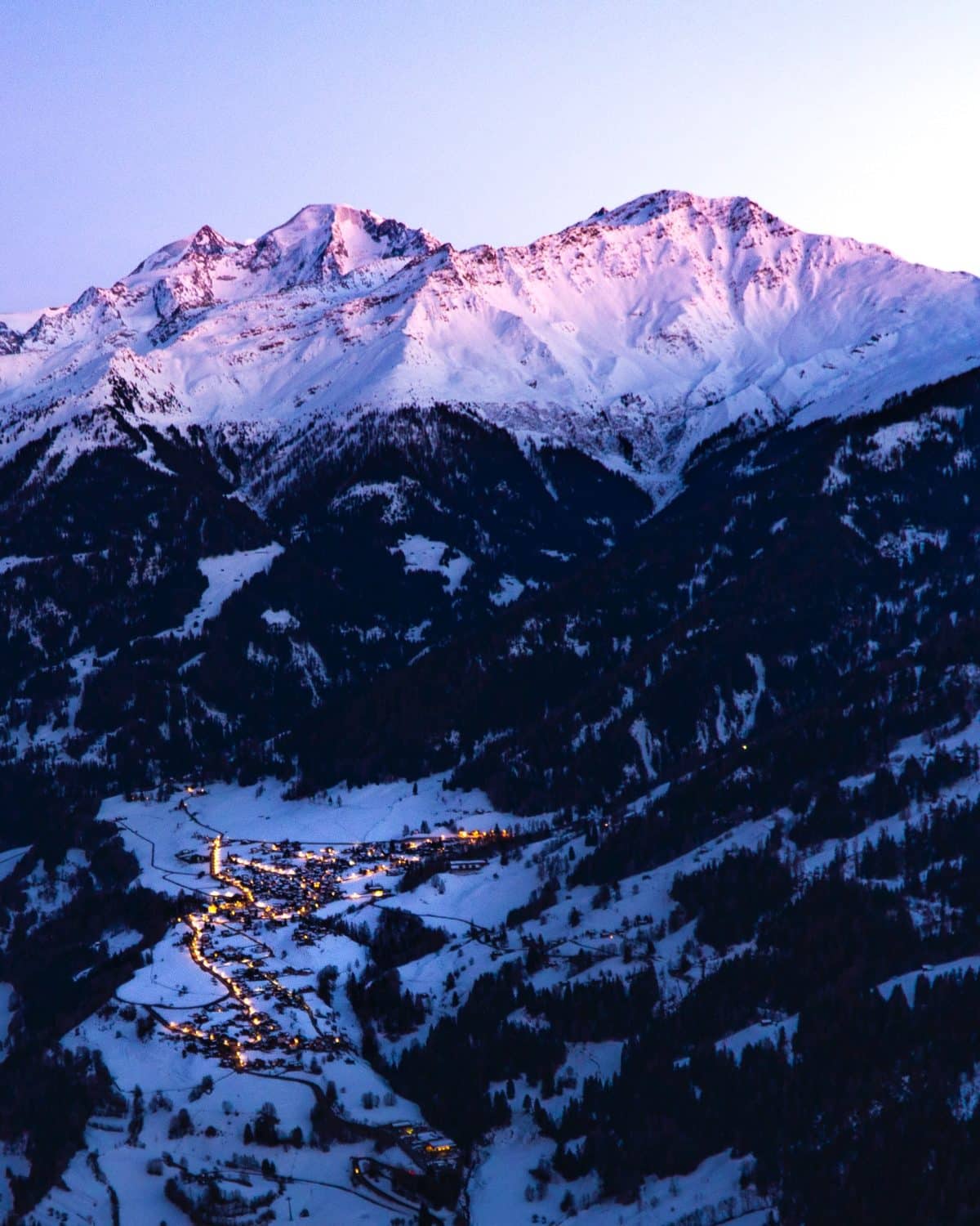 Station de ski Suisse en contrebas d'une montagne au couché du soleil