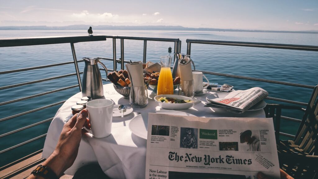 Homme prenant son petit déjeuner et lisant le journal du jour à bord d'une croisière