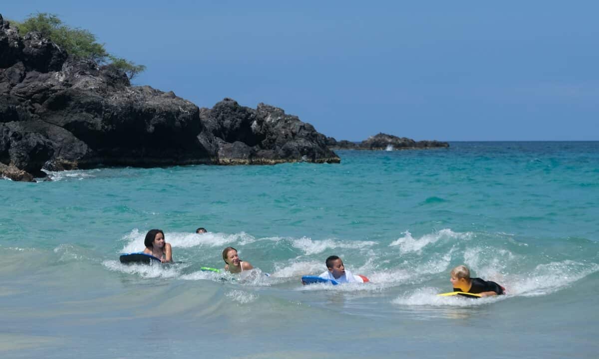 Enfants faisants du bodyboard pendant leurs vacances à la mer